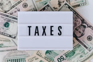 Owing taxes, getting refunds, and finding the sweet spot - "Taxes" quote box on top of stack of paper bills