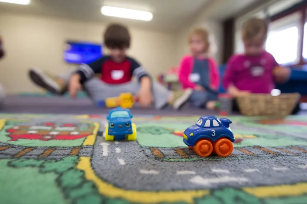 Thinking about cutting back on investing for daycare? Read this first - a group of children playing with toys on the floor