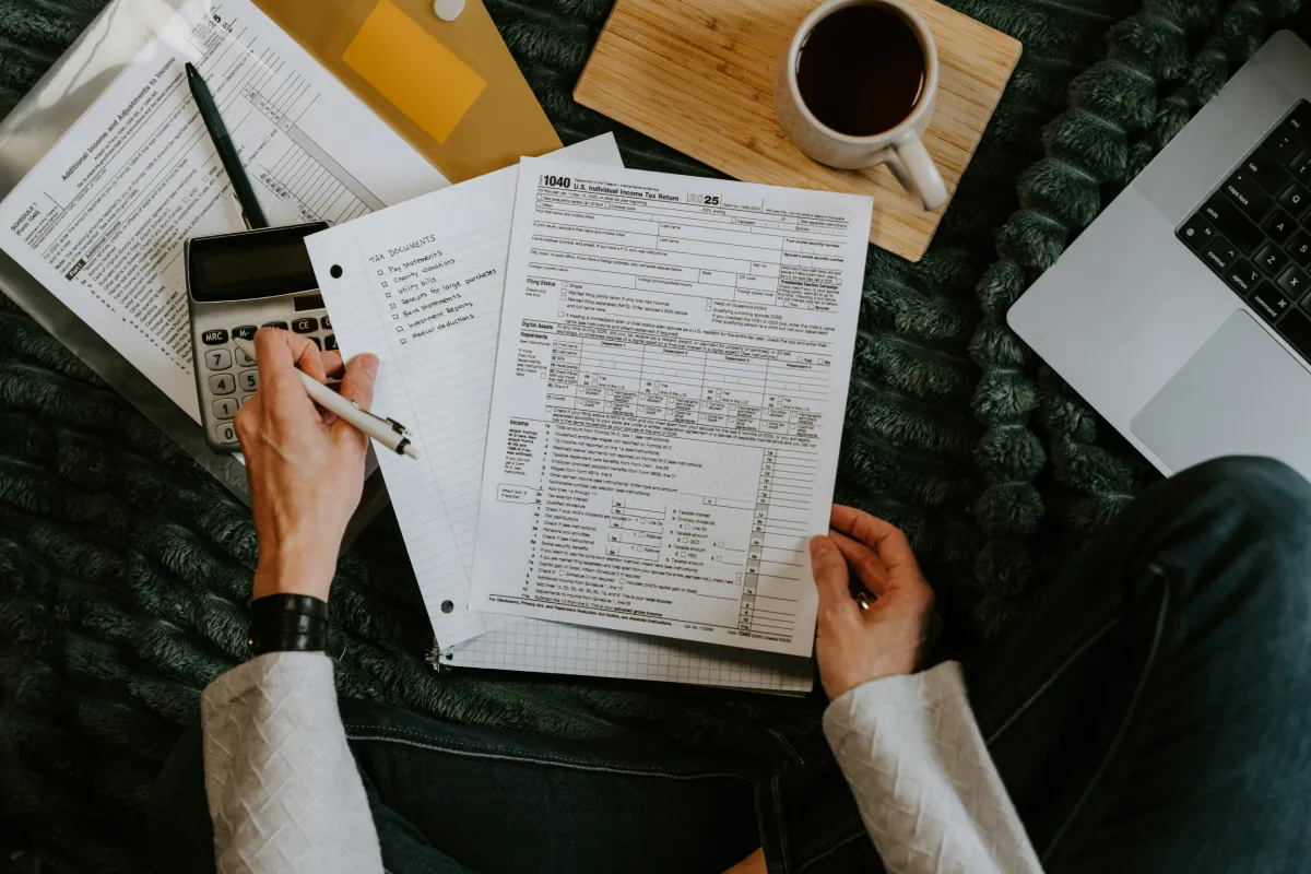 Retirement income planning isn’t just about avoiding taxes - person reviewing documents with calculator and laptop